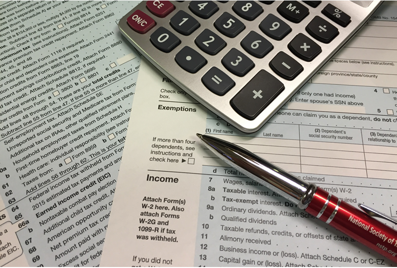 Tax forms, calculator and pen